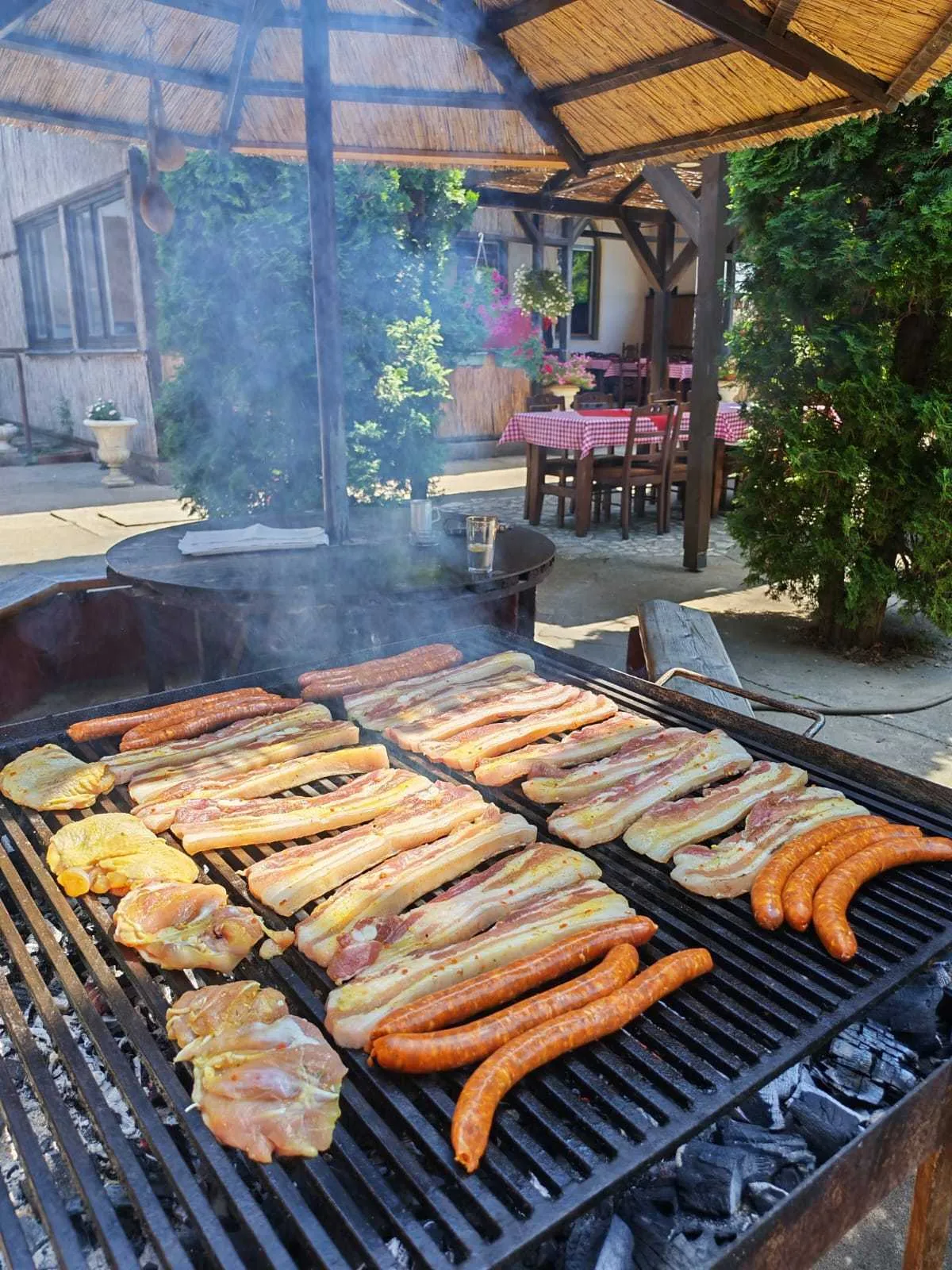 Faszénen sütés a csárda nádfedeles kertjében